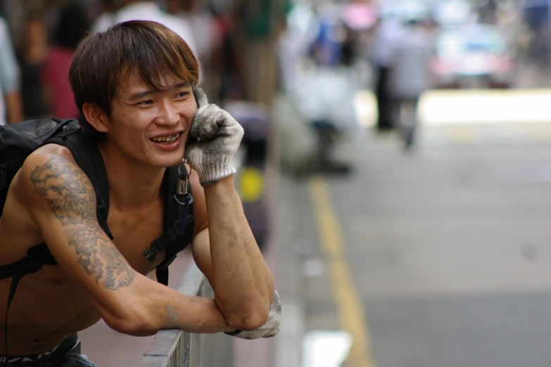 man with tattoos on face talking on cell phone