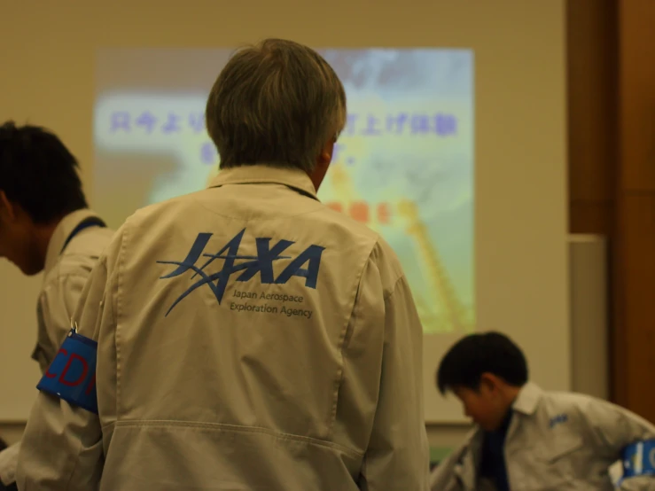 people in lab coats with a projection screen in the background