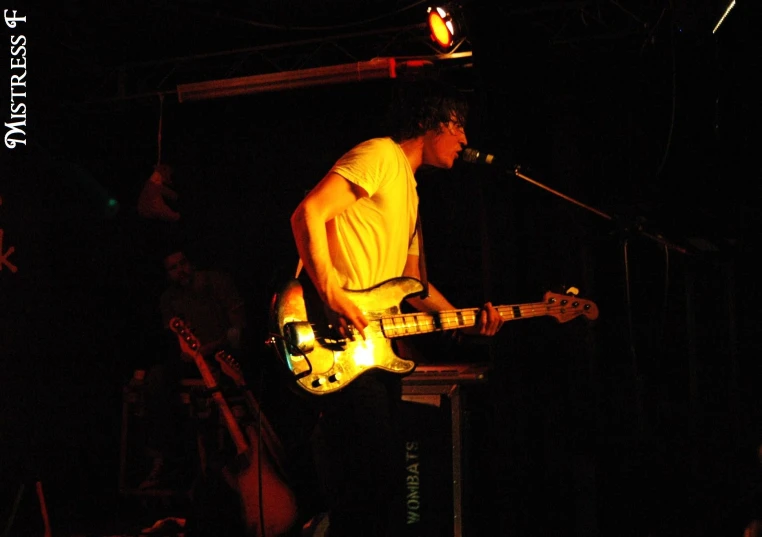 a guy playing an electric guitar in the dark