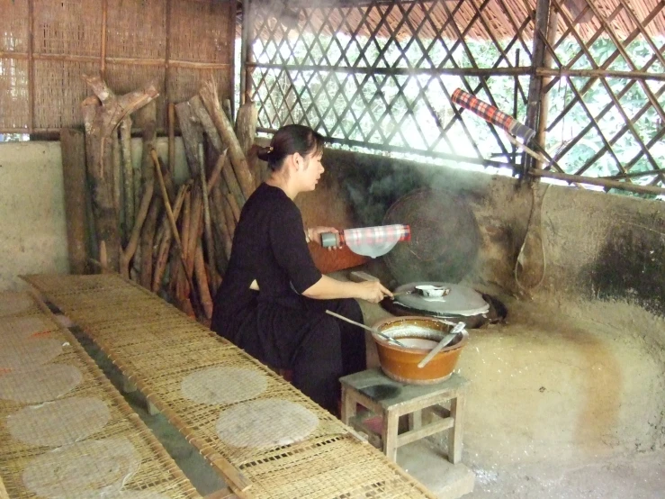 a woman stirring soing inside a pot on a stove