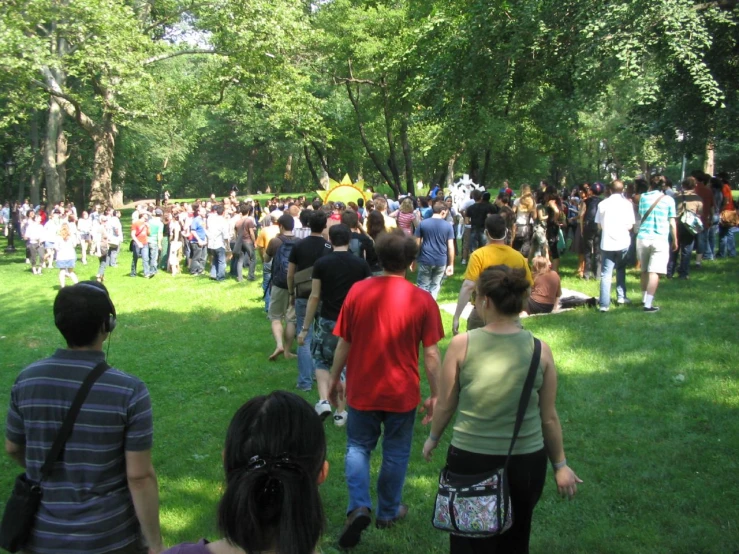 large group of people walking through grassy area