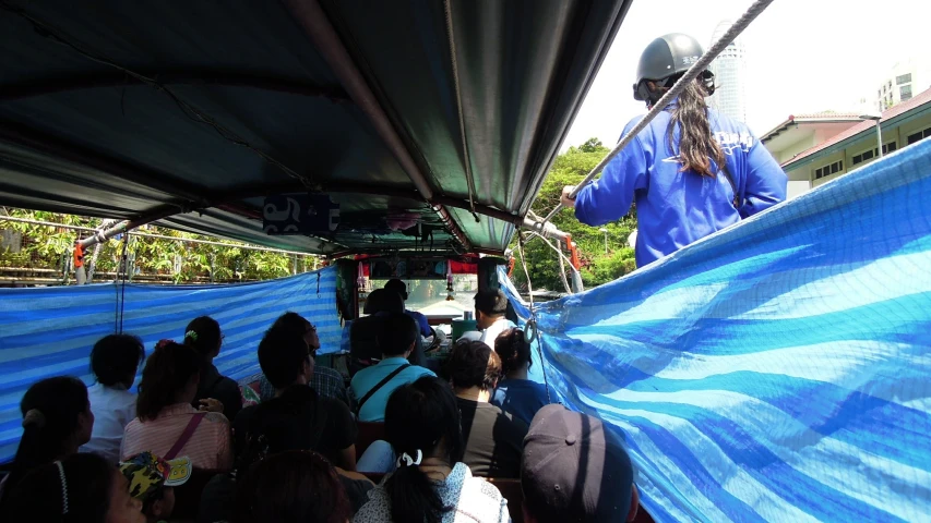 group of people watching man in blue suit on top of a bus