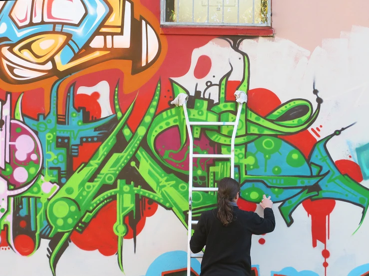a person painting graffiti on a wall