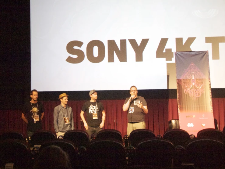 a group of people on stage with a screen