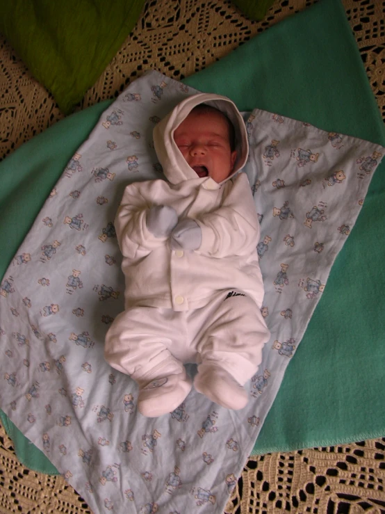 a baby laying on a blanket on a floor