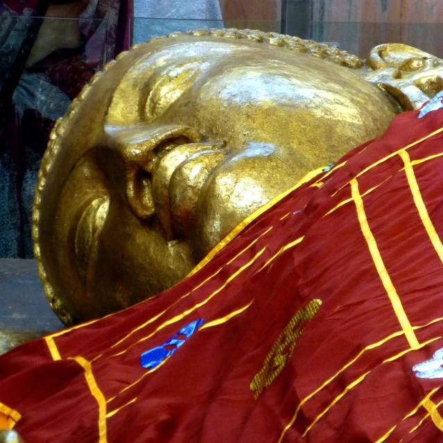 a large statue covered in red and yellow fabric