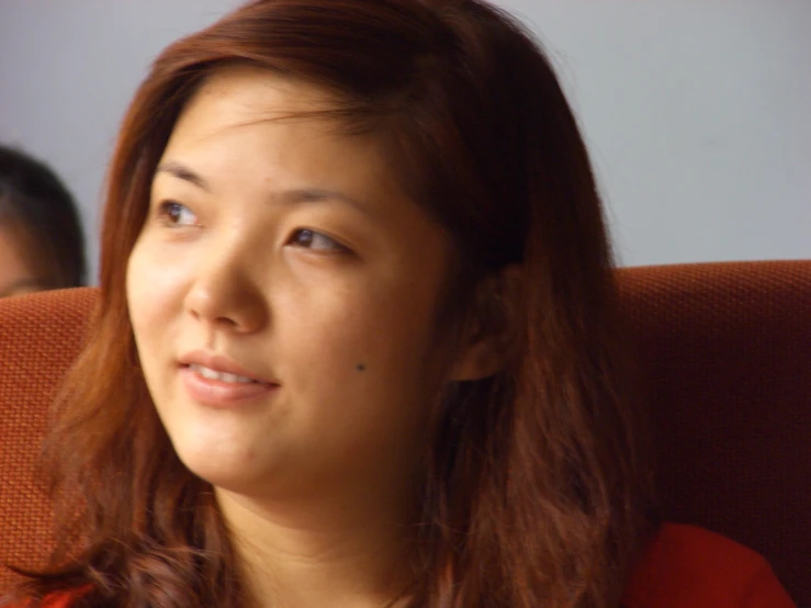 the woman is looking into the camera while sitting in a chair