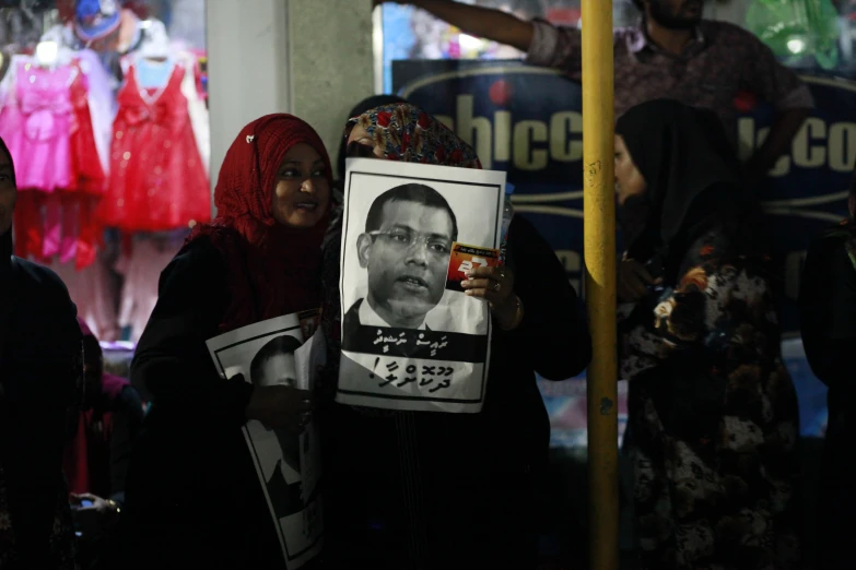 two women holding posters with the image of obama and biden