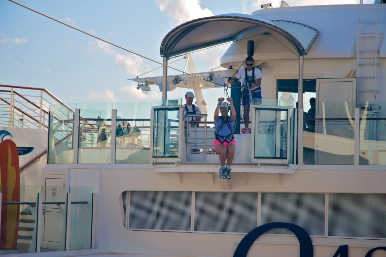 people walking on the bow deck of a ship with balcony railing