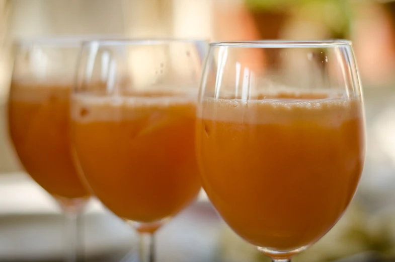 three wine glasses that are lined up with different wines