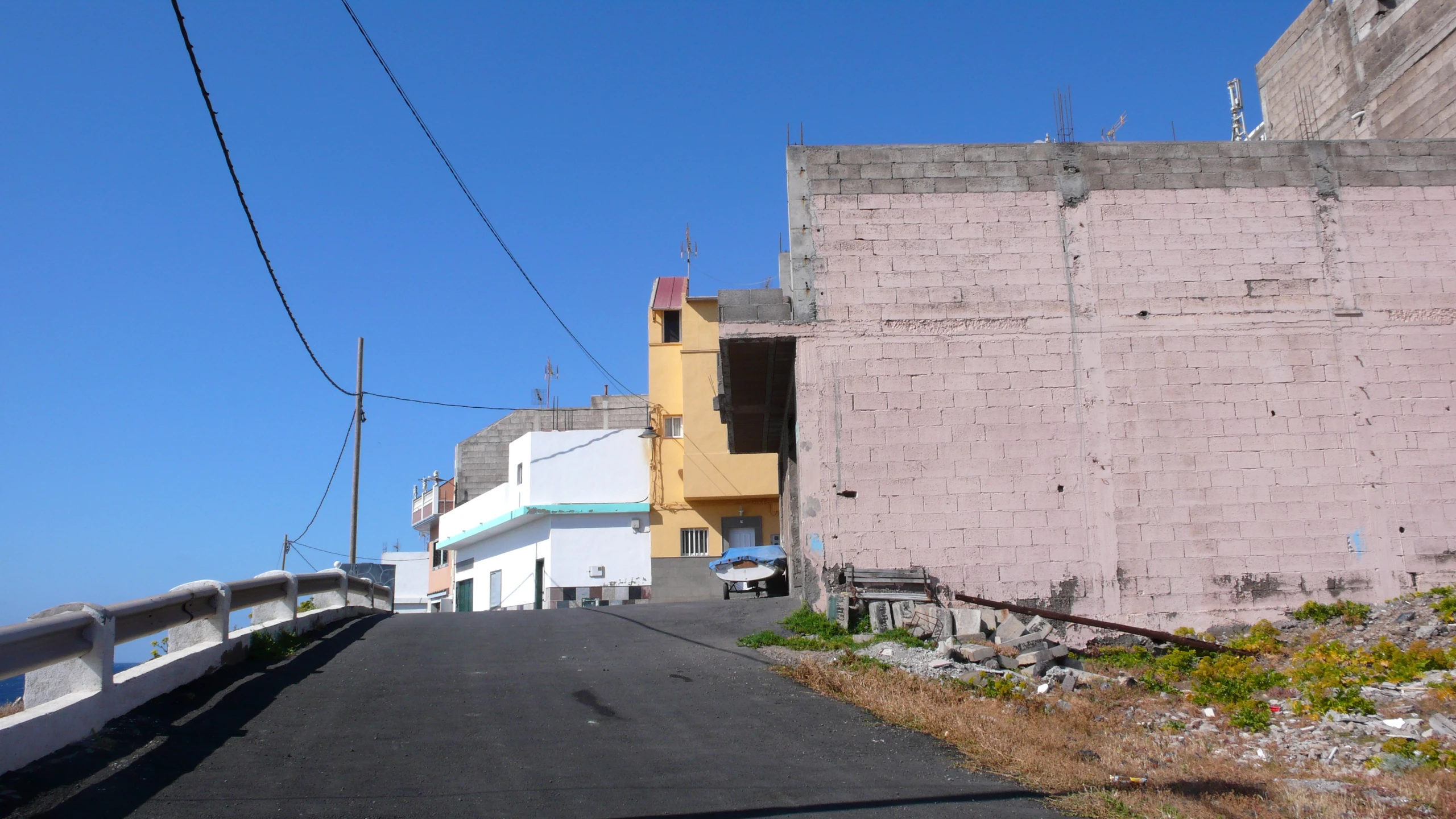 a narrow street has been paved with empty buildings