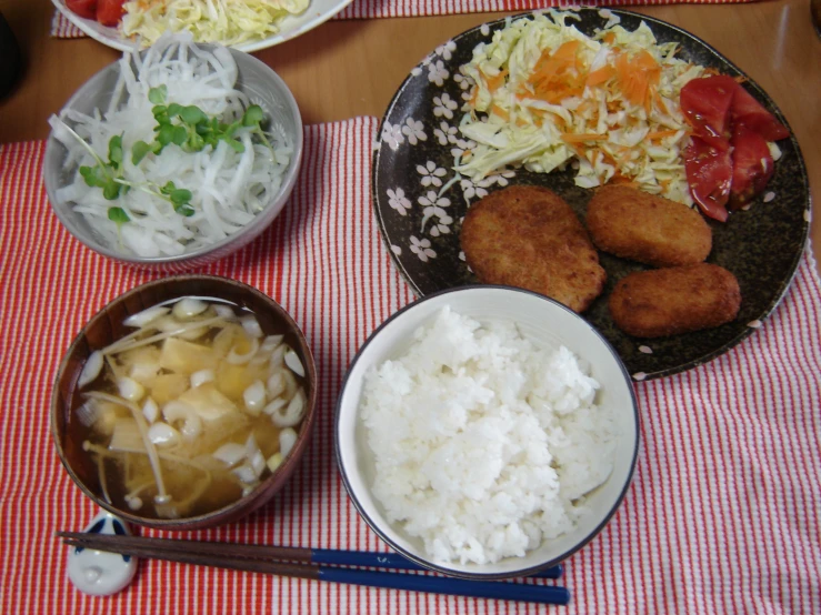 several different foods are on plates with chopsticks