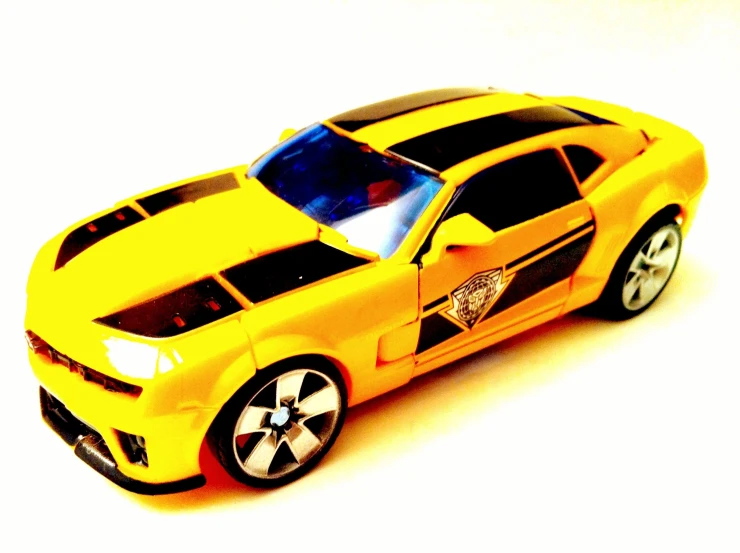 a yellow model car with a black and grey stripe