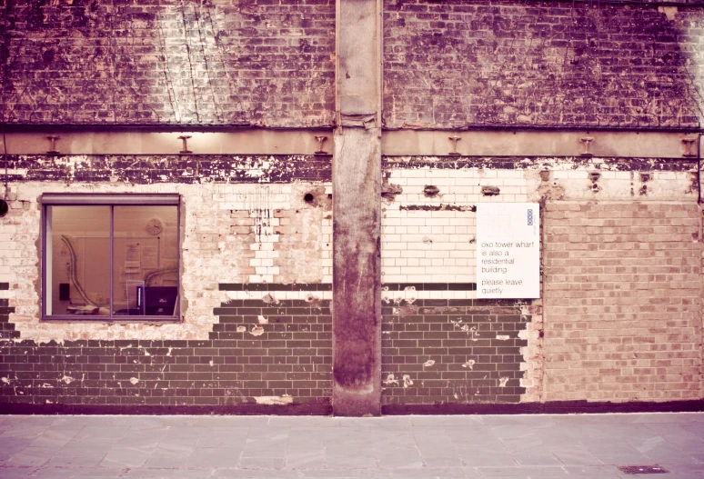 a fire hydrant near a brick wall with windows