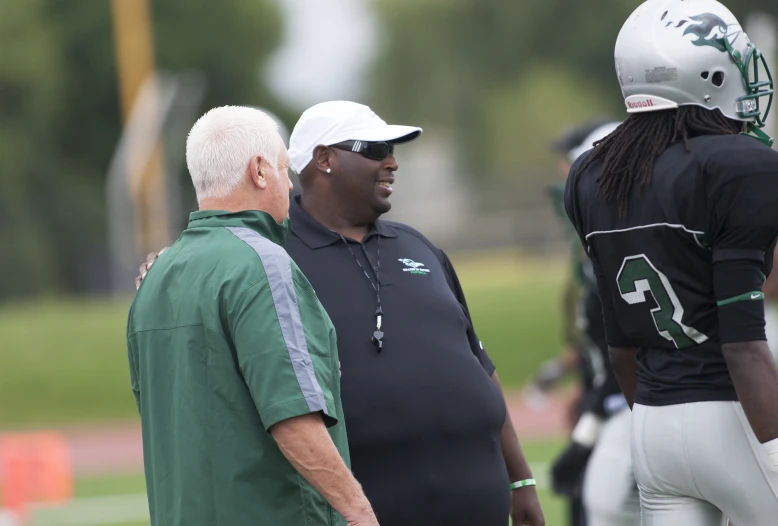 the football coaches are standing on the field