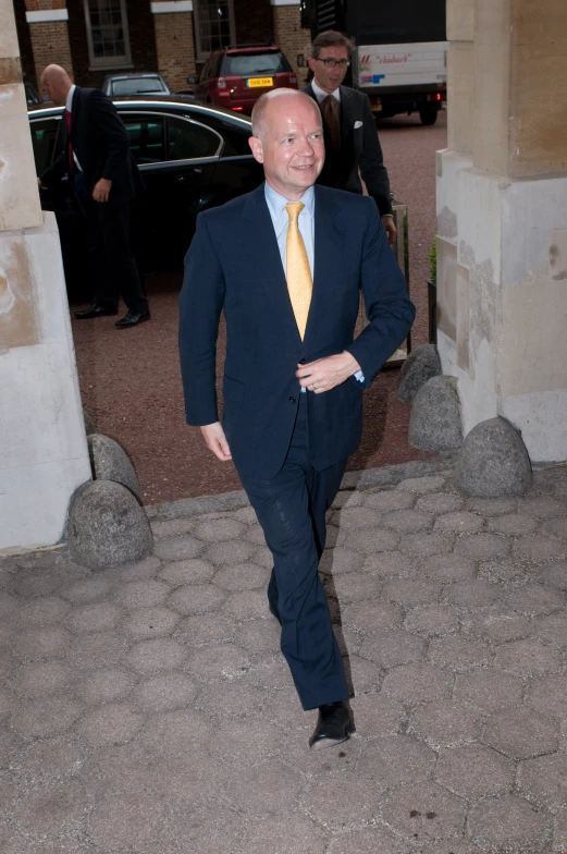 man in suit and yellow tie standing outside