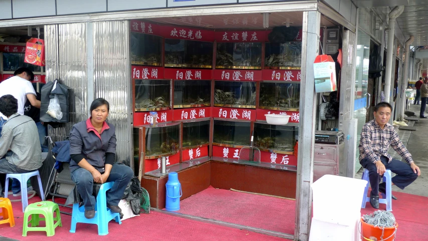 some people sitting in chairs outside of a store