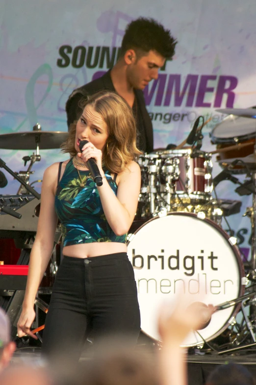 girl with microphone performing on stage at an event