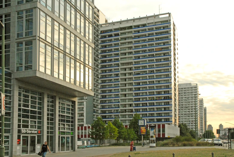 tall buildings sitting on the side of a street next to tall grass