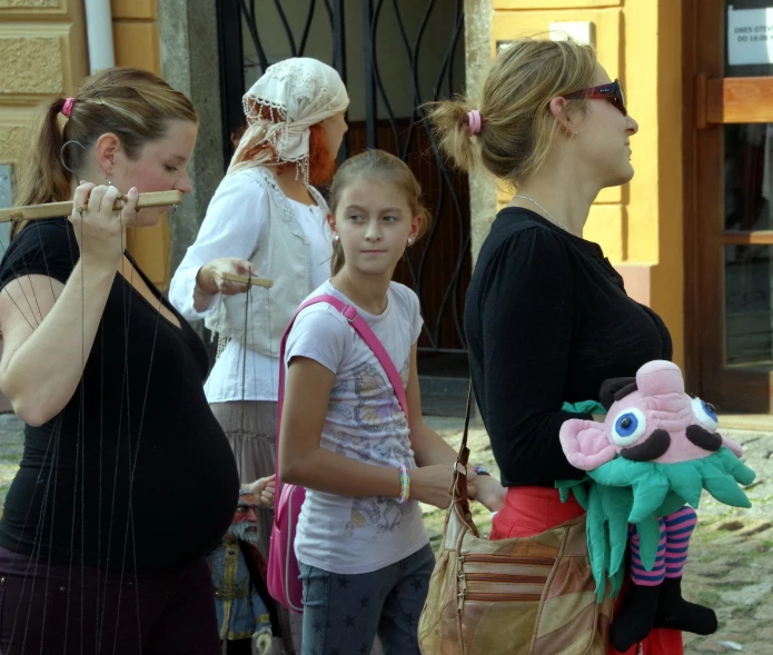 three women and two little girls are in line