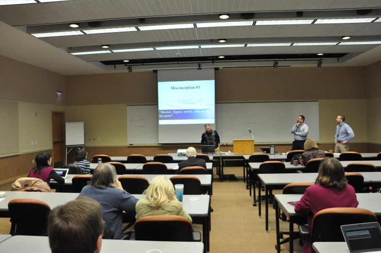 two people speaking to a group in a lecture hall