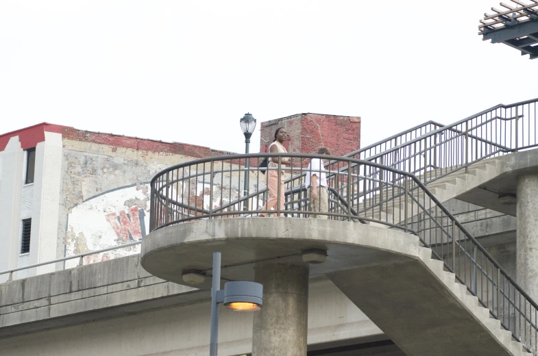 a man with a walking stick walks up a large bridge