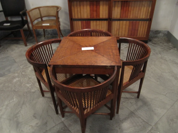 a wooden table surrounded by brown chairs in a room