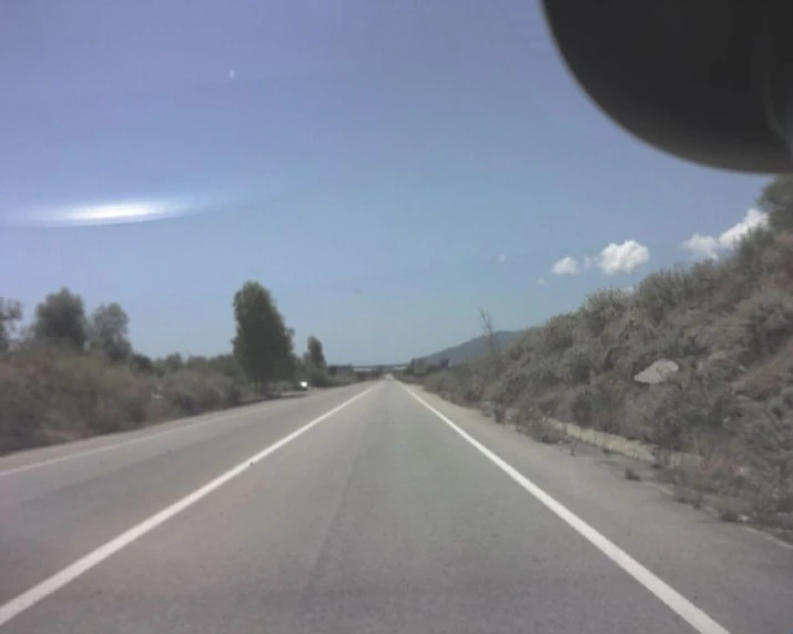 the dashboard view of a vehicle on the side of a road