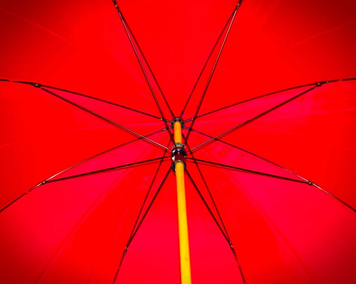 an open red umbrella with an orange pole