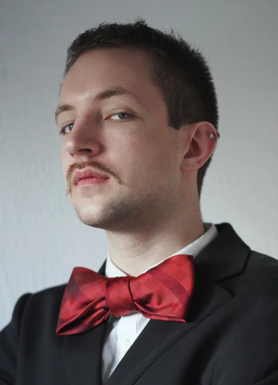 a man wearing a red bow tie looking up