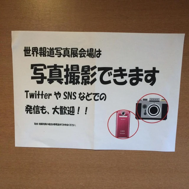 a poster with a red camera next to a white sign