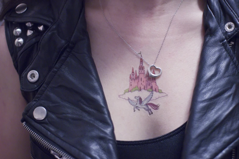 woman with a tattoo is wearing a black jacket and has a pink castle on it