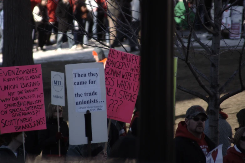 several protest signs that are attached to a pole