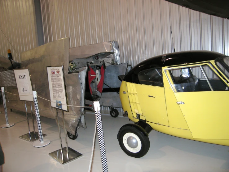 a close - up of an old fashioned yellow vehicle on display