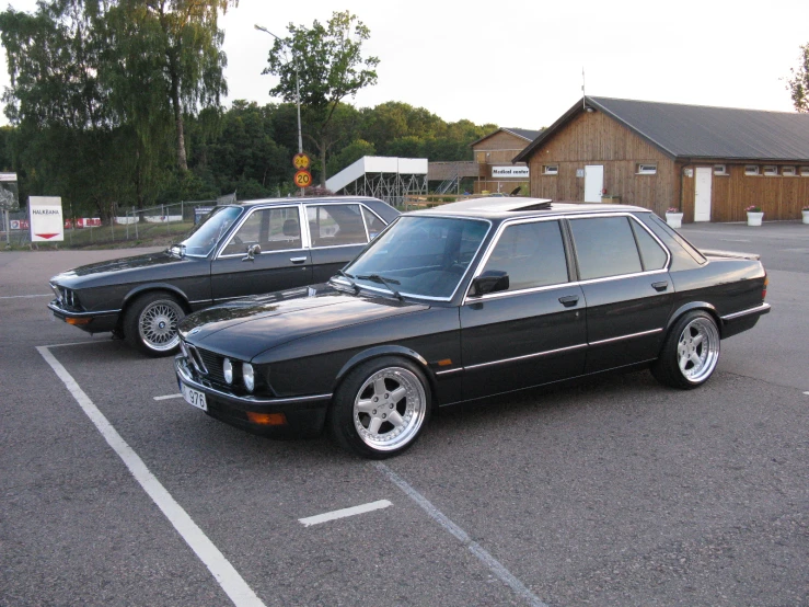 an old bmw in a parking lot at an event