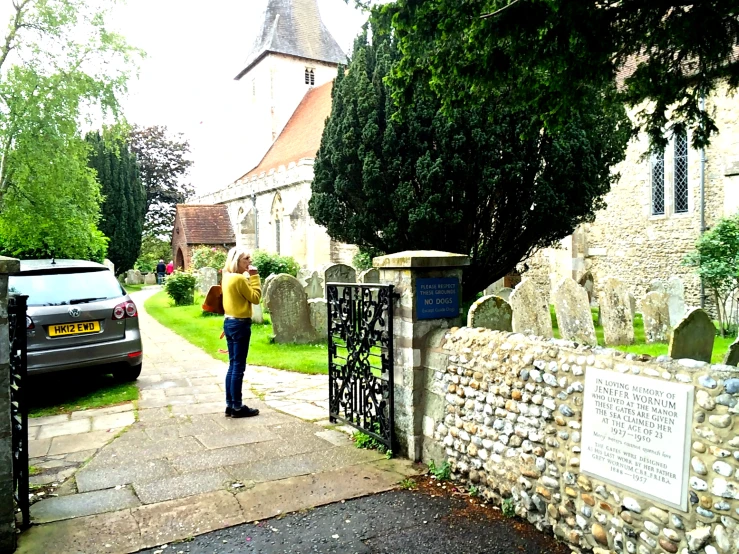 a woman walking up to an old stone church