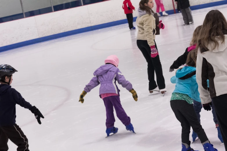 a group of s skating on the ice rink