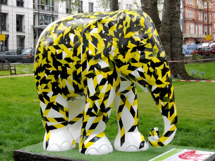 a brightly painted elephant on a bench next to a building