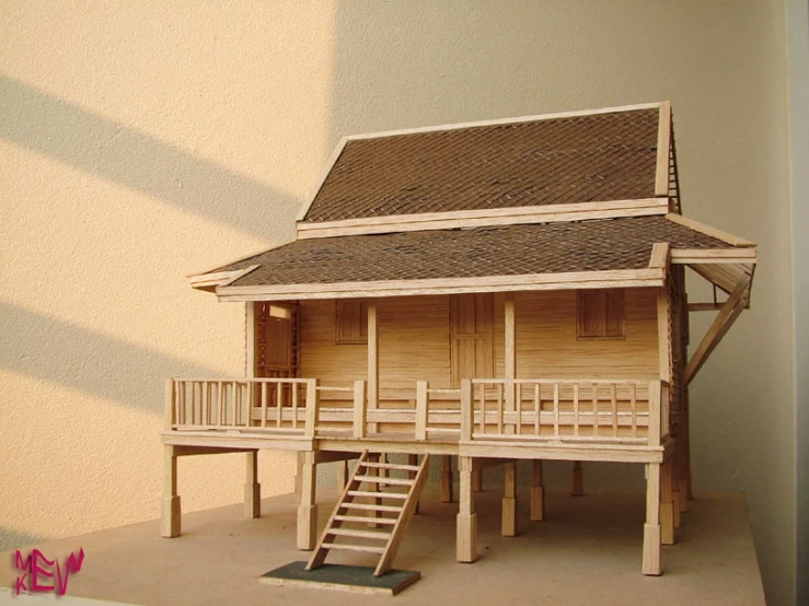wooden house on display next to stairs and a table
