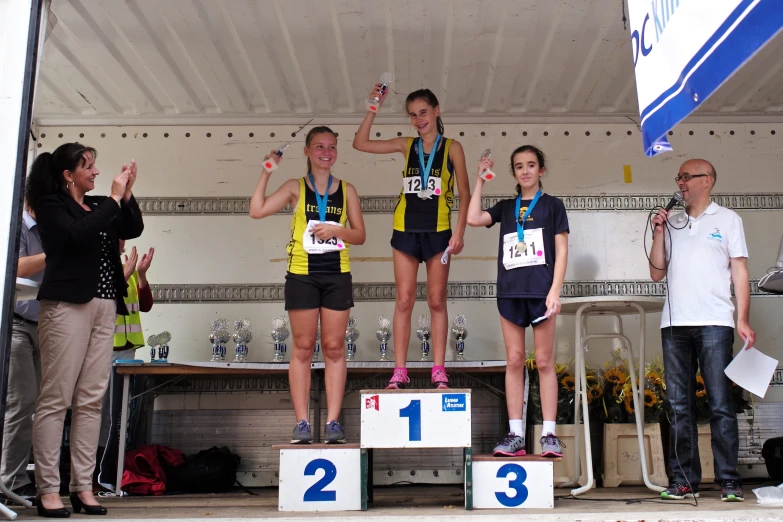 three people on the podium with their medals