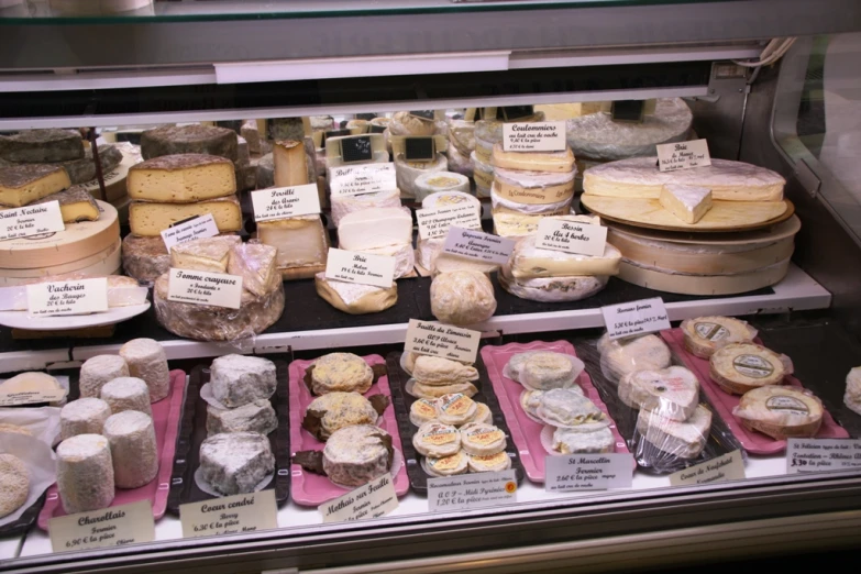 a display case filled with lots of different types of cheese