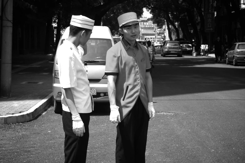 two women in uniforms standing near a white truck