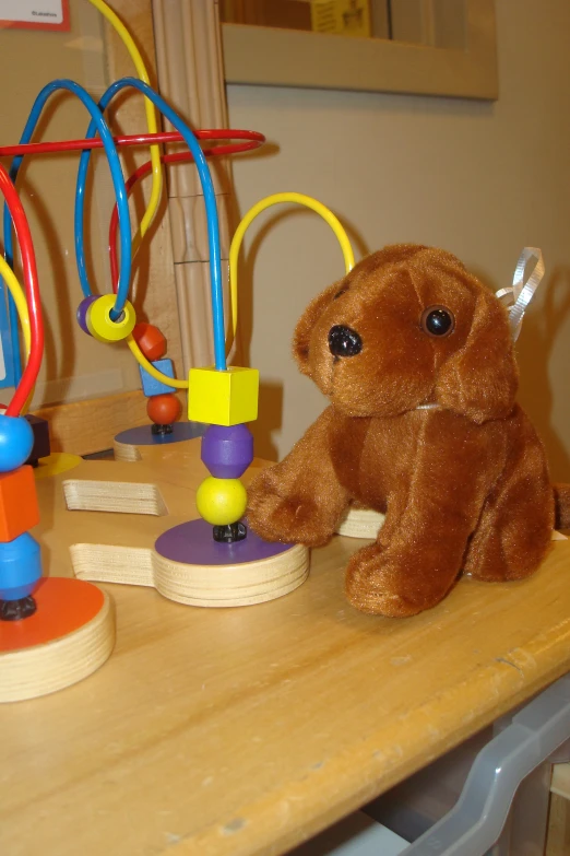 a brown teddy bear with many different beads and toy rings