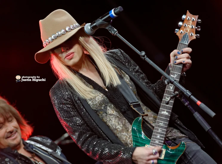 the singer performs on stage with her guitar