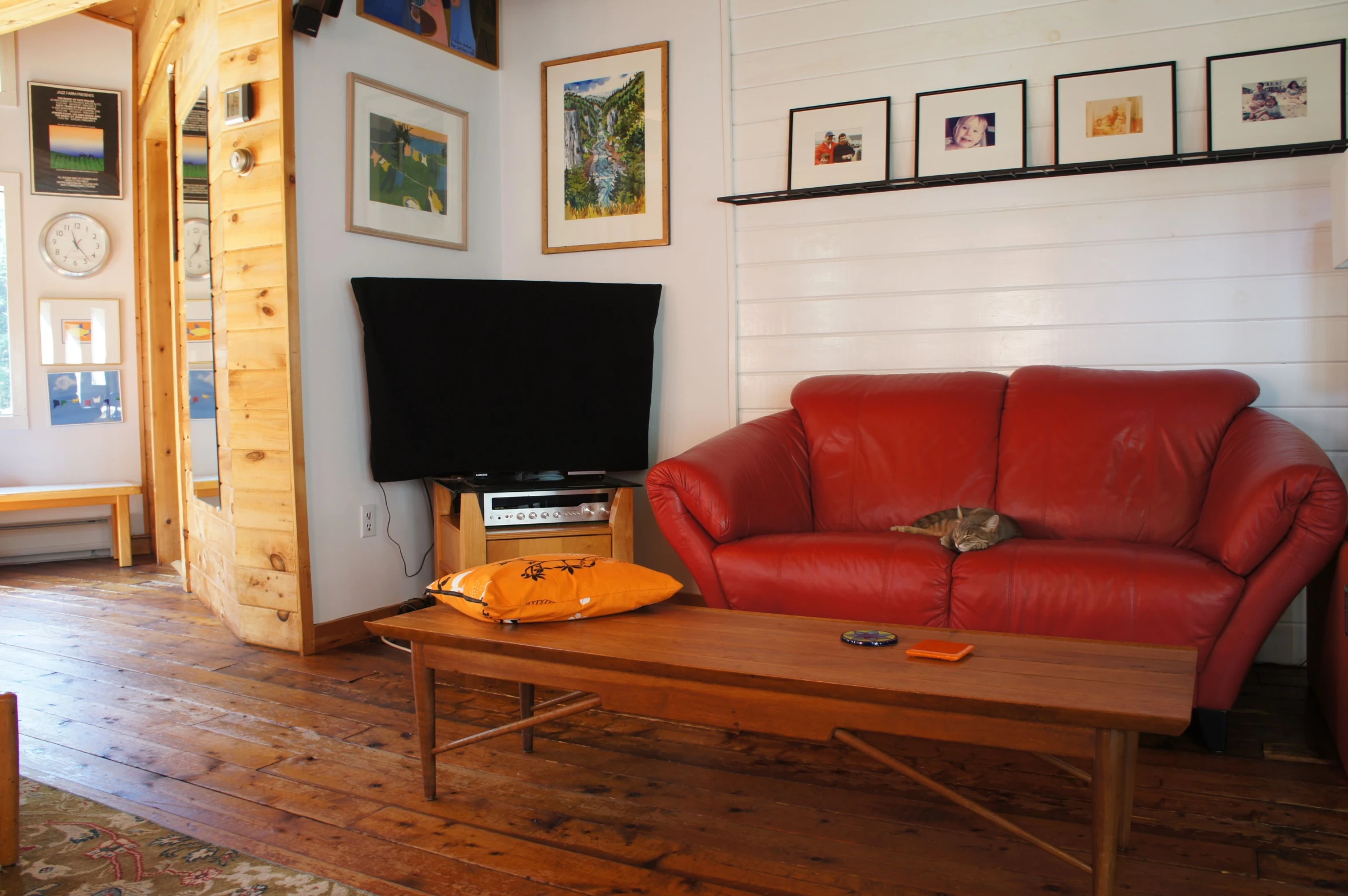 a red leather couch in a wooden living room