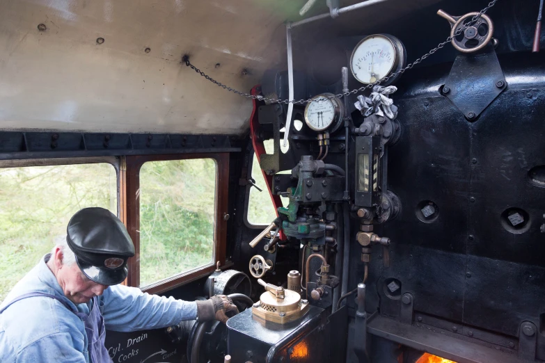 a man adjusts some clocks on the window of a train