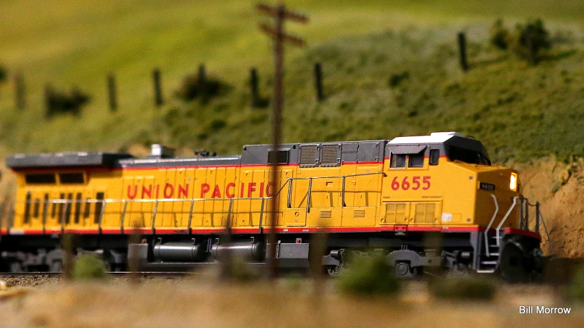 a yellow train traveling through the country side