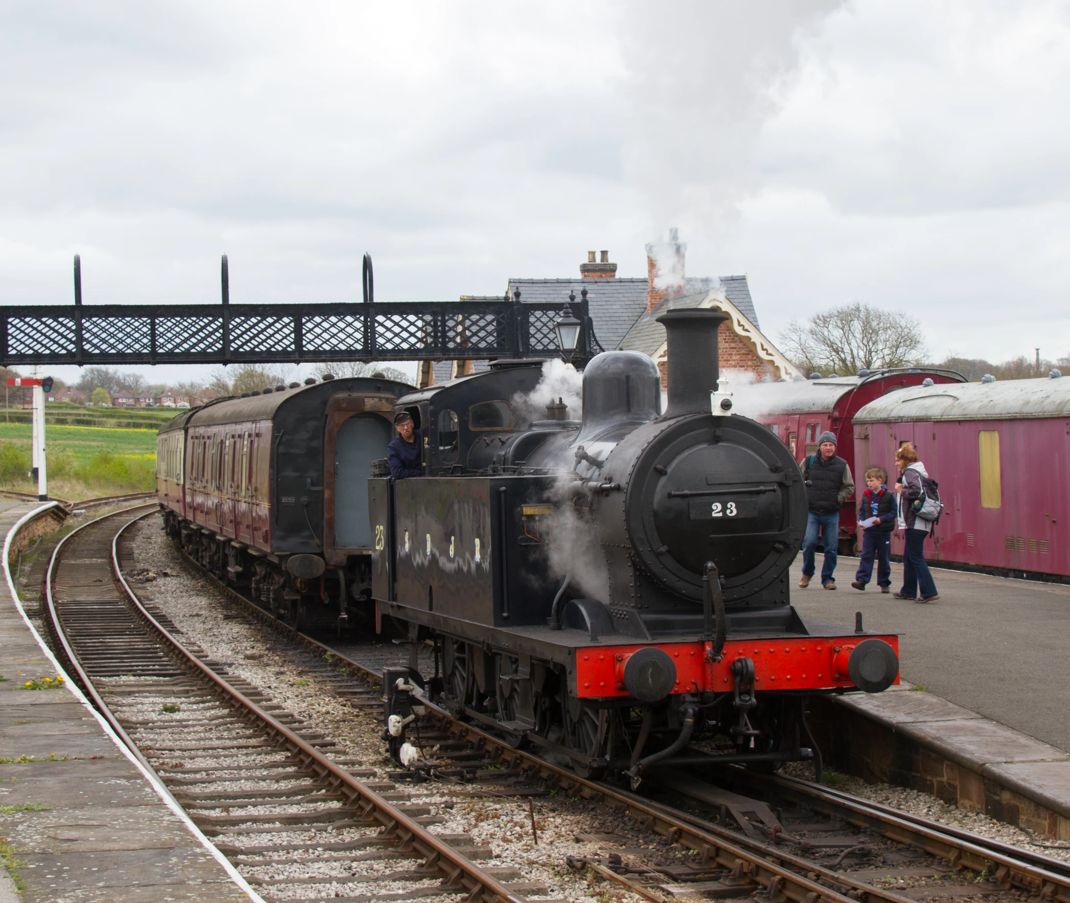 old steam locomotive on the tracks with people looking at