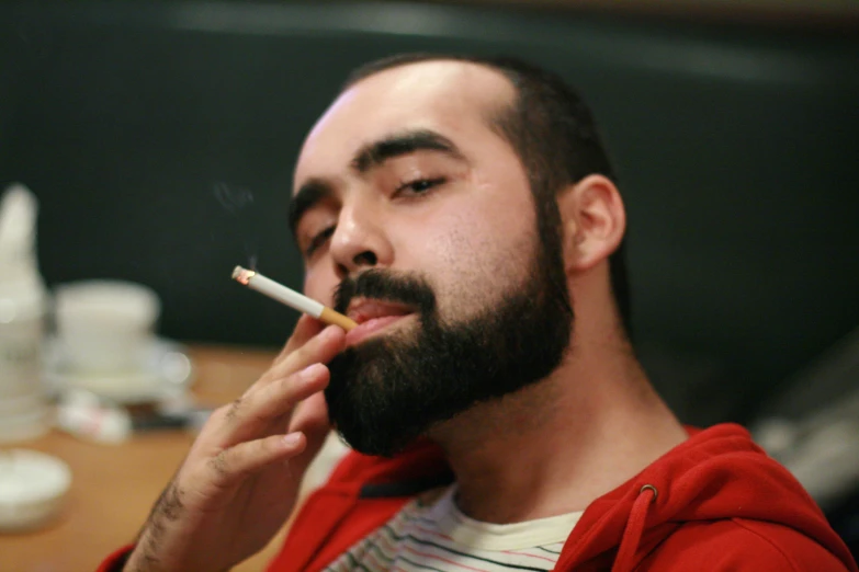 a man with a beard smoking a cigarette