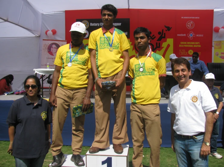 the men are standing on the podium of a competition